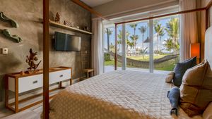Luxury beachfront villa interior with modern furnishings and panoramic ocean views through floor-to-ceiling windows.