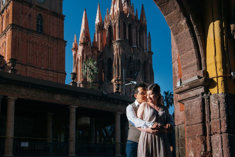 A couple stands in front of historic red brick buildings during their wedding photo session in Europe.
