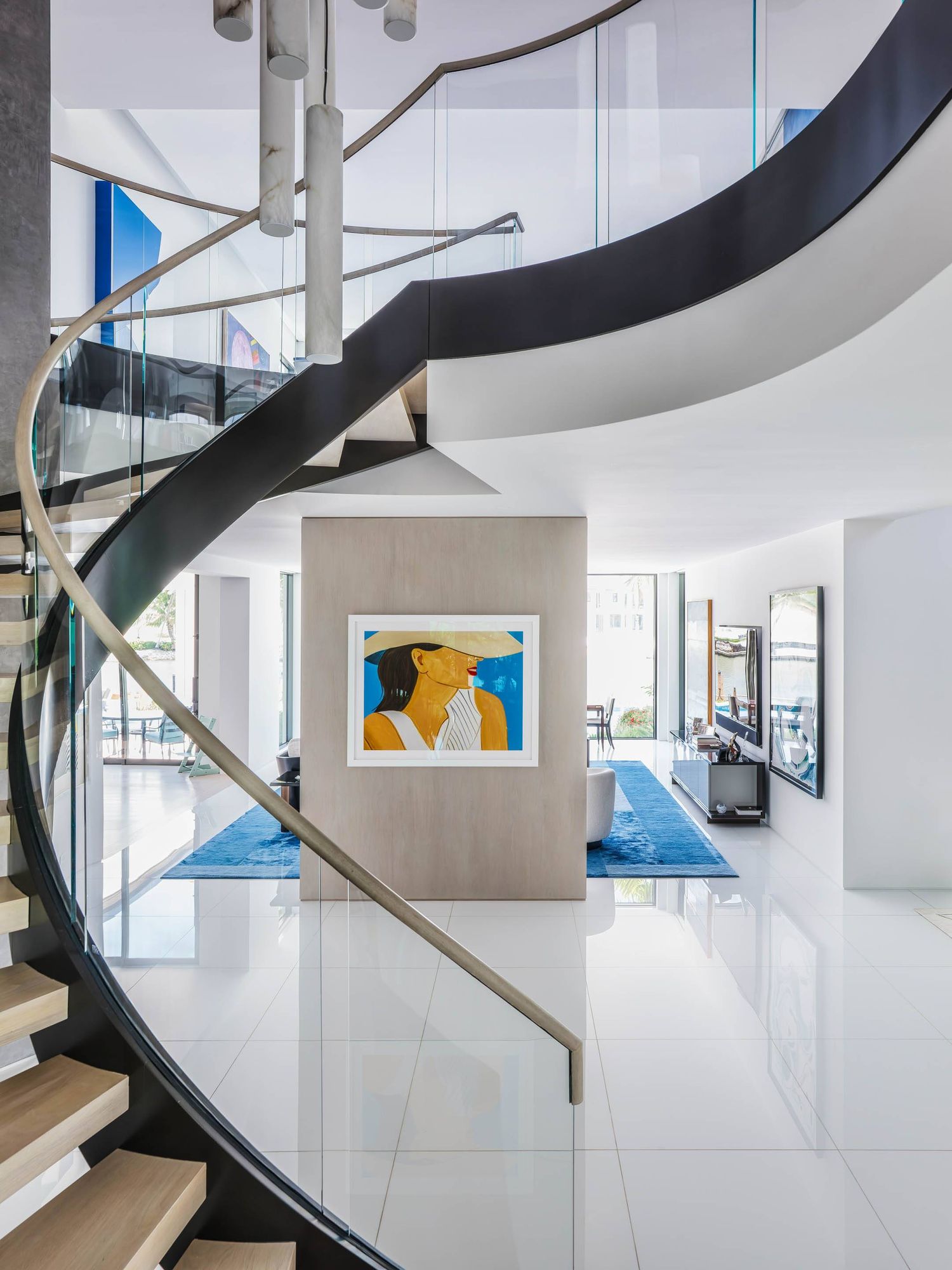 Elegant spiral staircase with black railing and wooden steps in a bright contemporary interior.