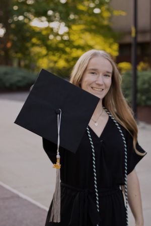 A woman holding her graduation cap out for graduation