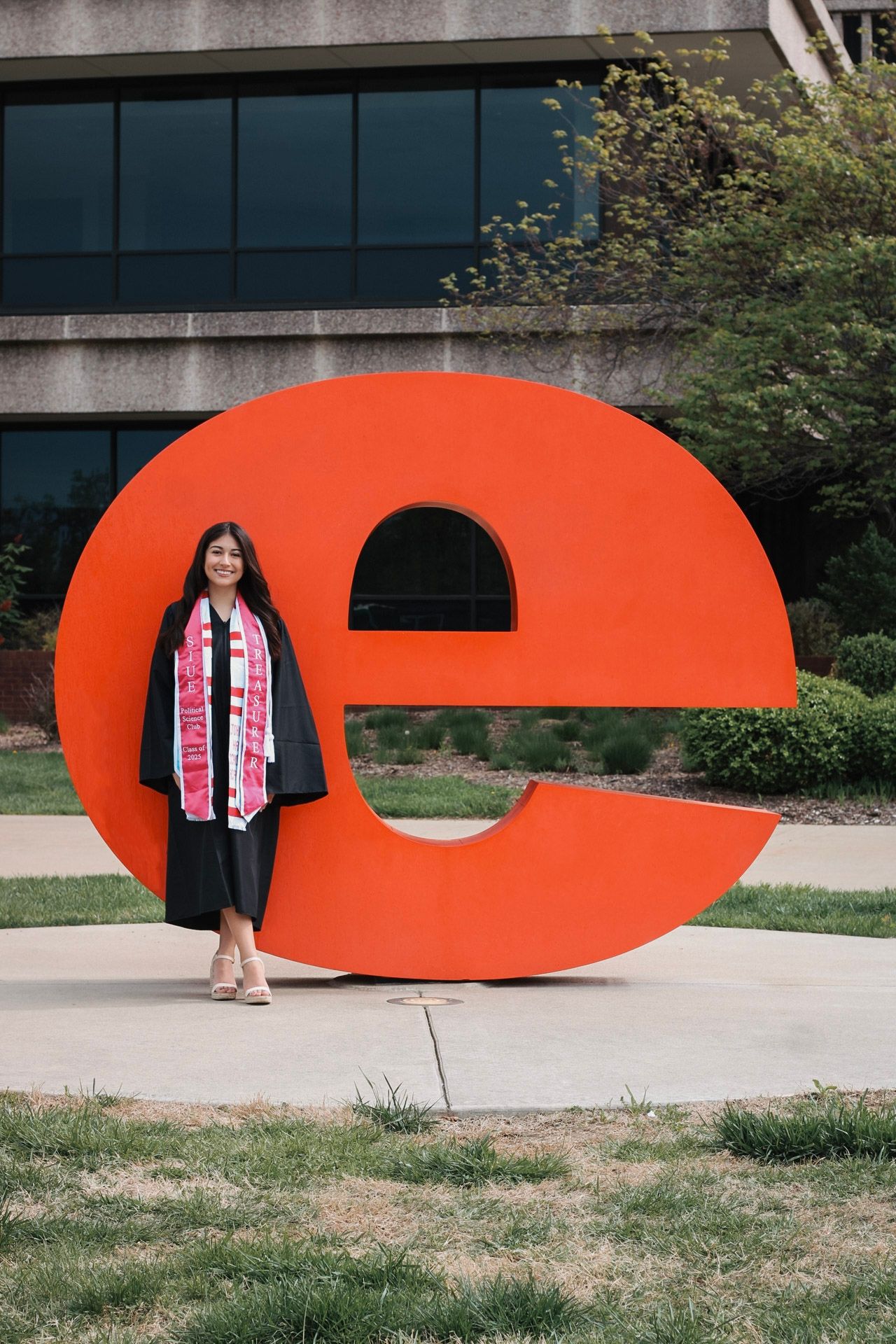 Young woman posing outside by a statue at Southern Illinois University Edwardsville for graduation