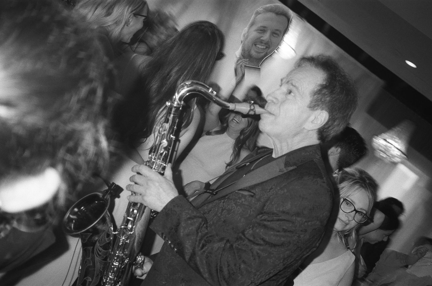 Musicians playing saxophones and instruments in a dimly lit jazz club setting.