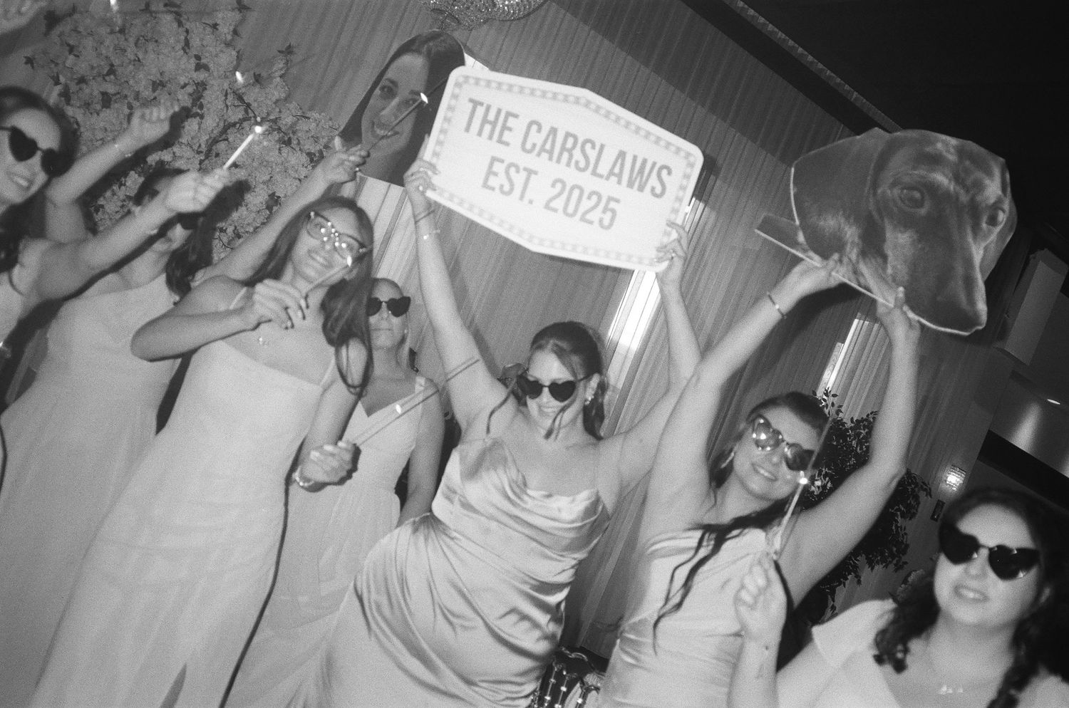 A black and white photo strip showing four sequential party photos with people posing and having fun.