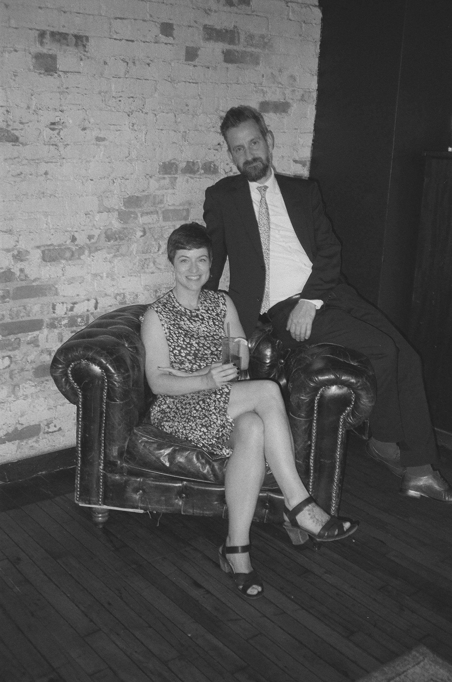A series of black and white photos showing someone seated in a leather armchair against a brick wall.