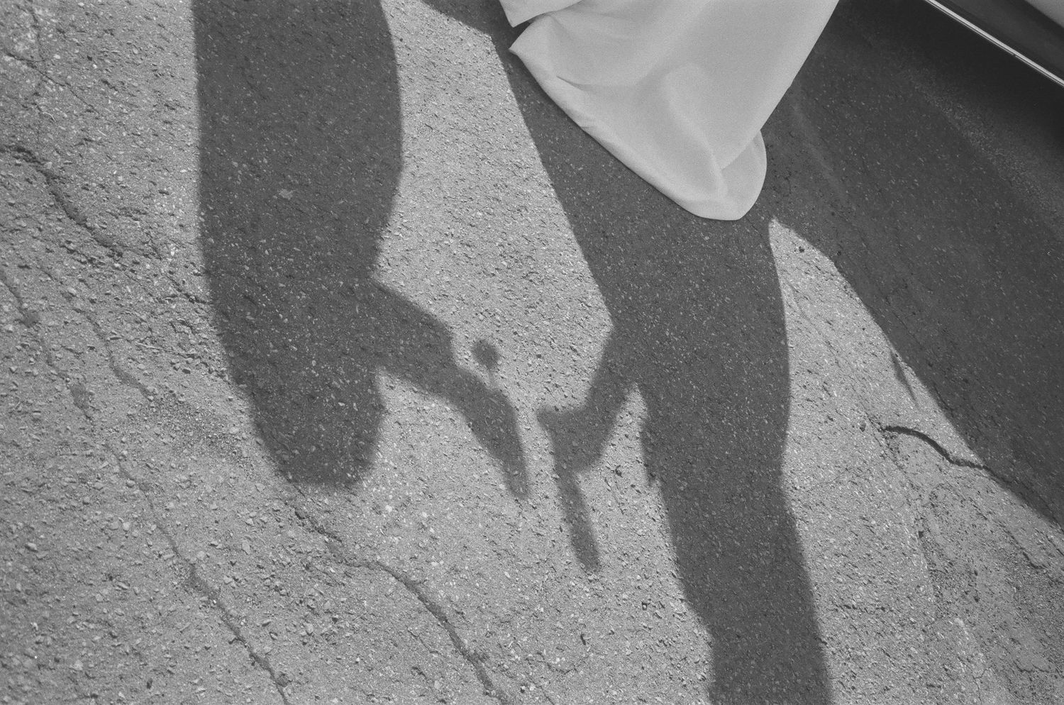 Shadow silhouettes cast on a textured wall or ground surface.
