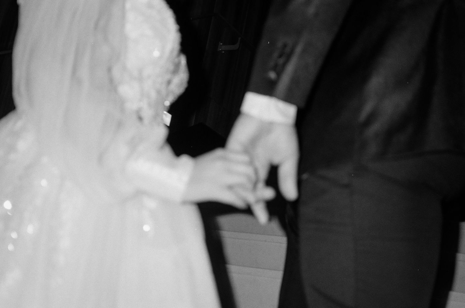 A couple dancing at a formal event, with the woman wearing a white dress and man in dark suit.