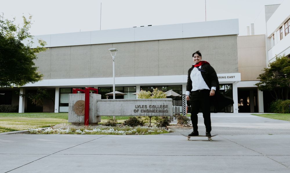 Someone stands at the entrance of a modern commercial building with clean architectural lines on an overcast day.