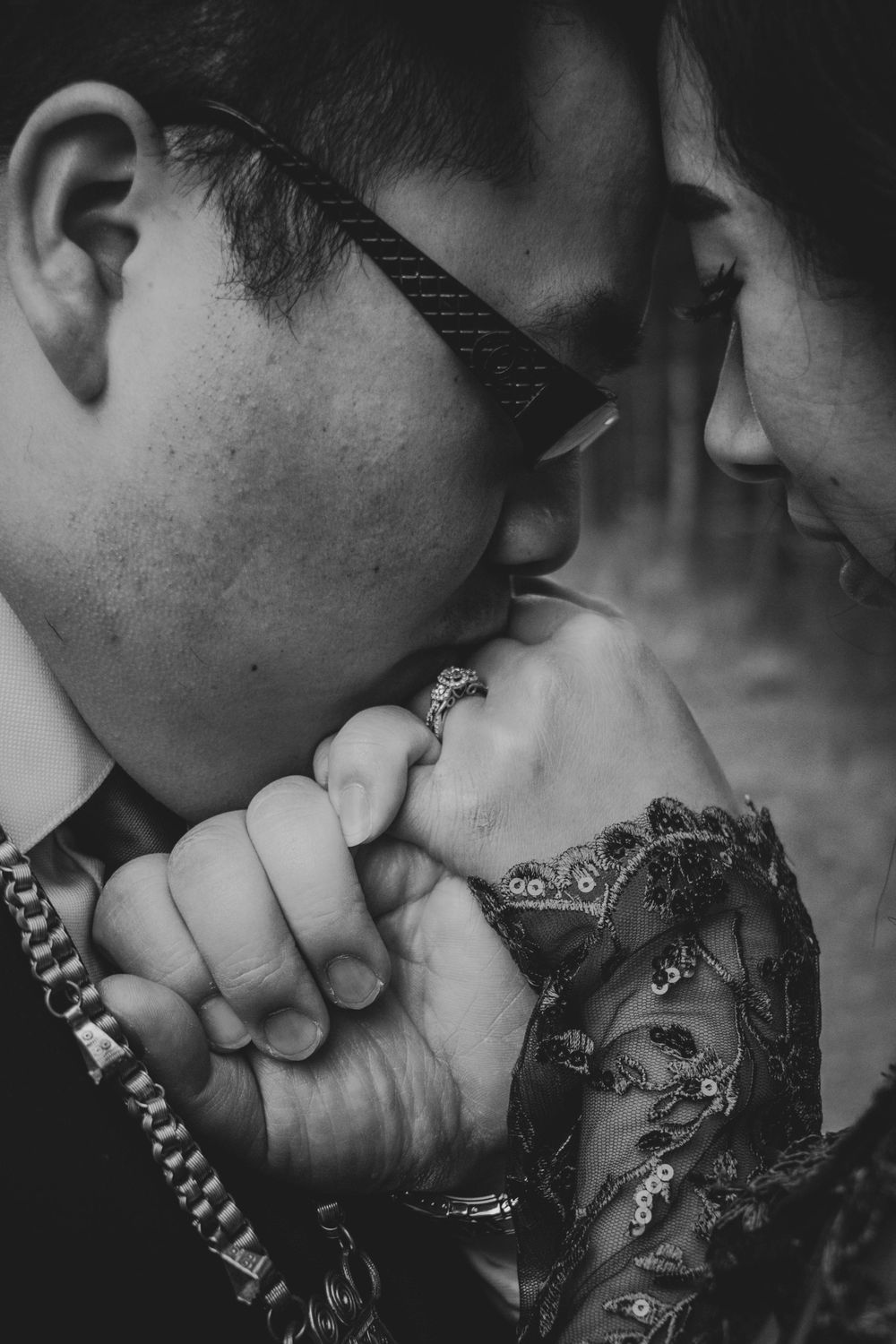 A romantic black and white photo series showing a couple kissing while wearing elegant masquerade masks.