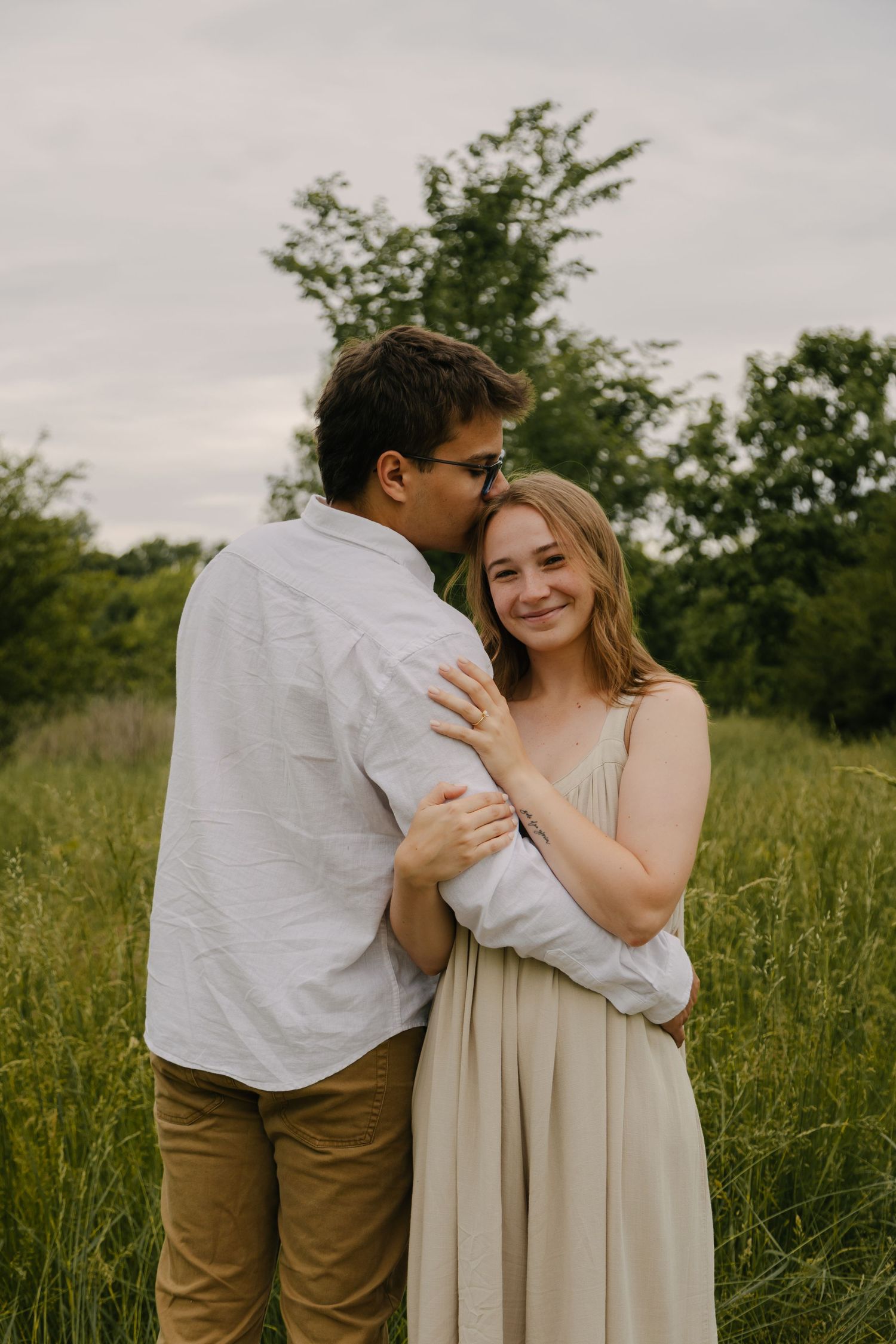 Couple sitting together on concrete surface during sunset.