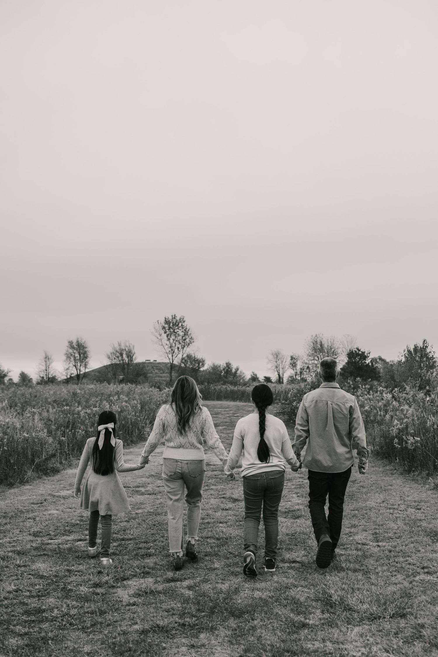 Couple walking together along a stone path surrounded by greenery.