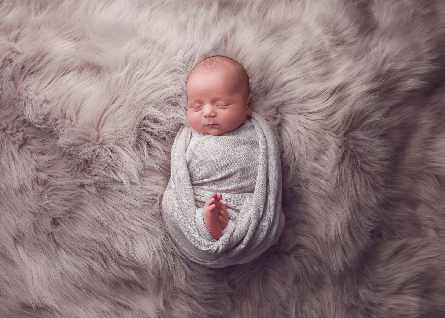 A peaceful newborn baby boy wrapped in soft fabrics, captured in a serene and intimate setting, showcasing the delicate beauty of early life