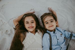Children in formal attire smiling together in a bright setting. Sarasota best family photographer 2026