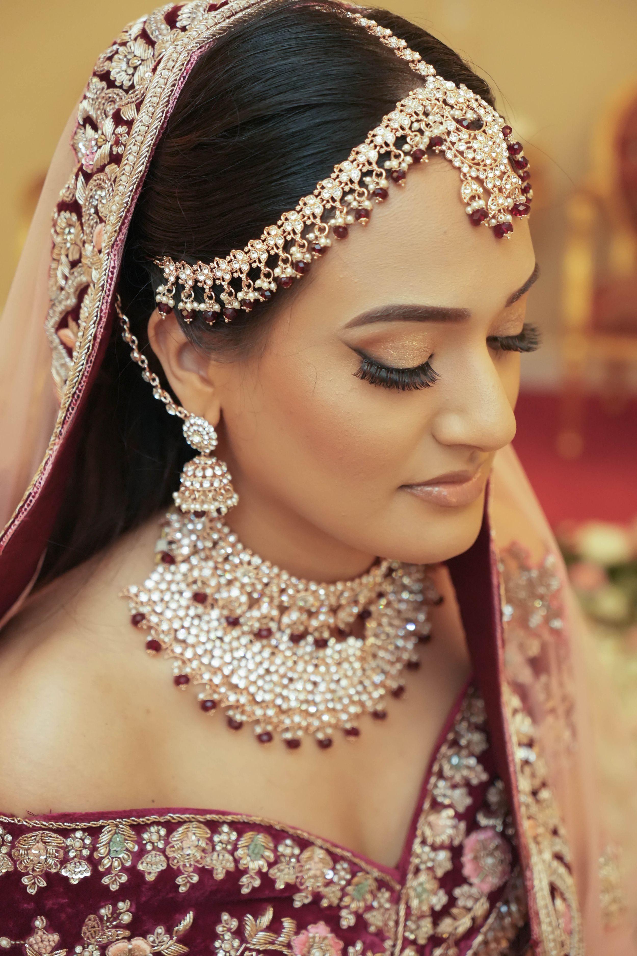 Traditional Indian bridal jewelry and makeup with ornate pearl and crystal headpiece.