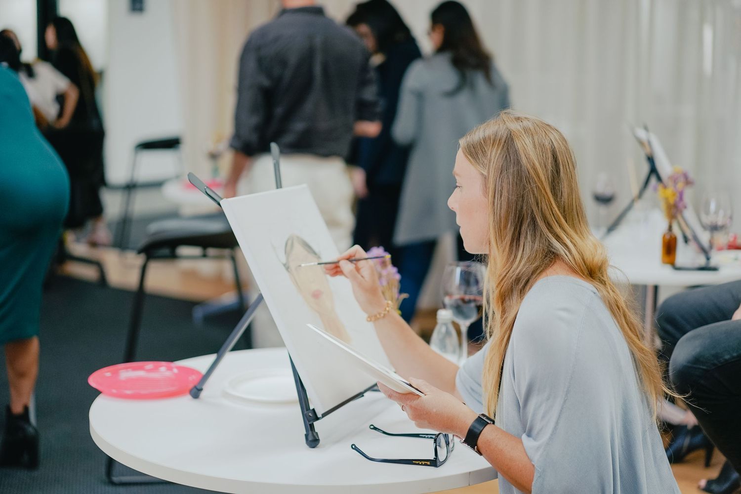 Artist sketching at desk in creative studio space.