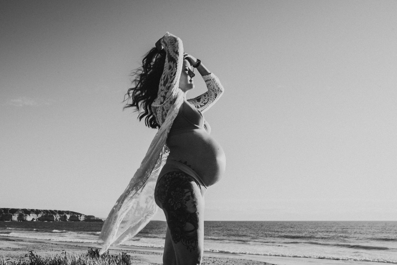 Silhouette maternity photos taken at sunset on a beach.
