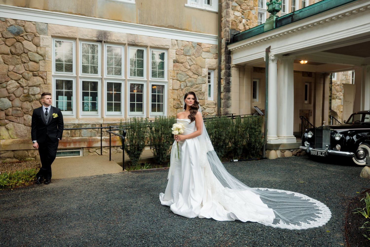 Romantic garden wedding with couple embracing among colorful floral arrangements and archways.