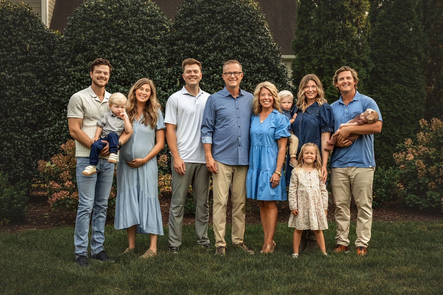 A series of outdoor family portraits showing coordinated outfits in blue and neutral tones against a garden backdrop.