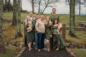 A series of outdoor extended family portraits taken on a wooded hillside with matching casual outfits in earth tones.
