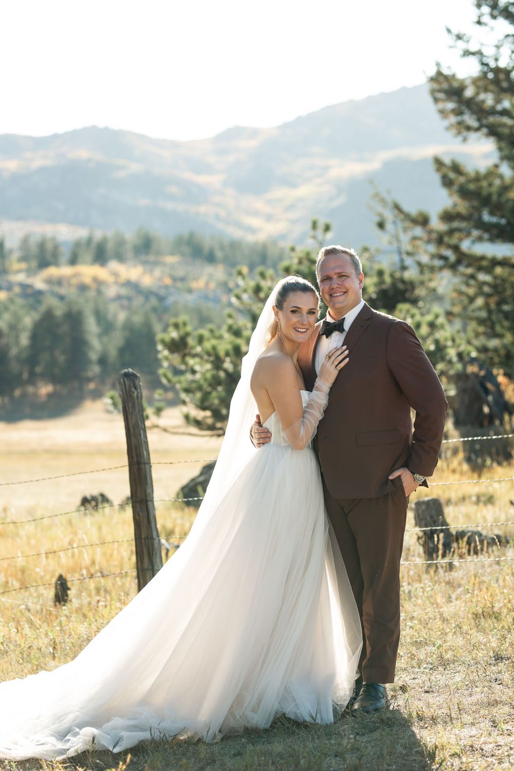 Scenic mountain wedding portrait on a golden hillside.