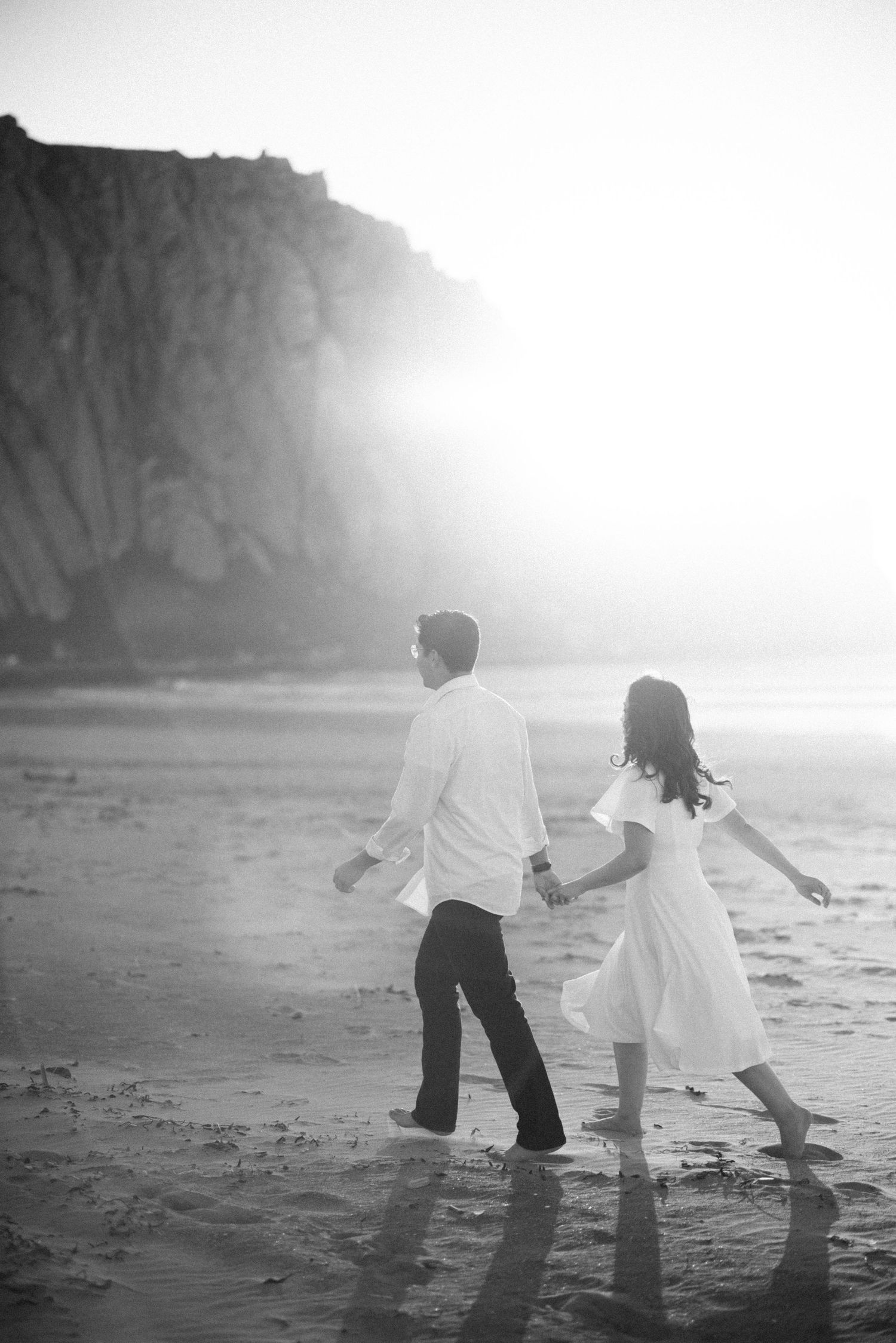 Photo of Jazzlin & Caleb walking on a California beach