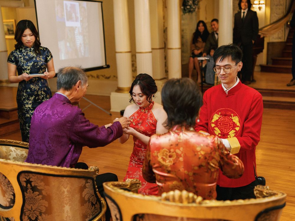 Elderly residents in wheelchairs participate in a social gathering at a senior living facility with festive decorations.