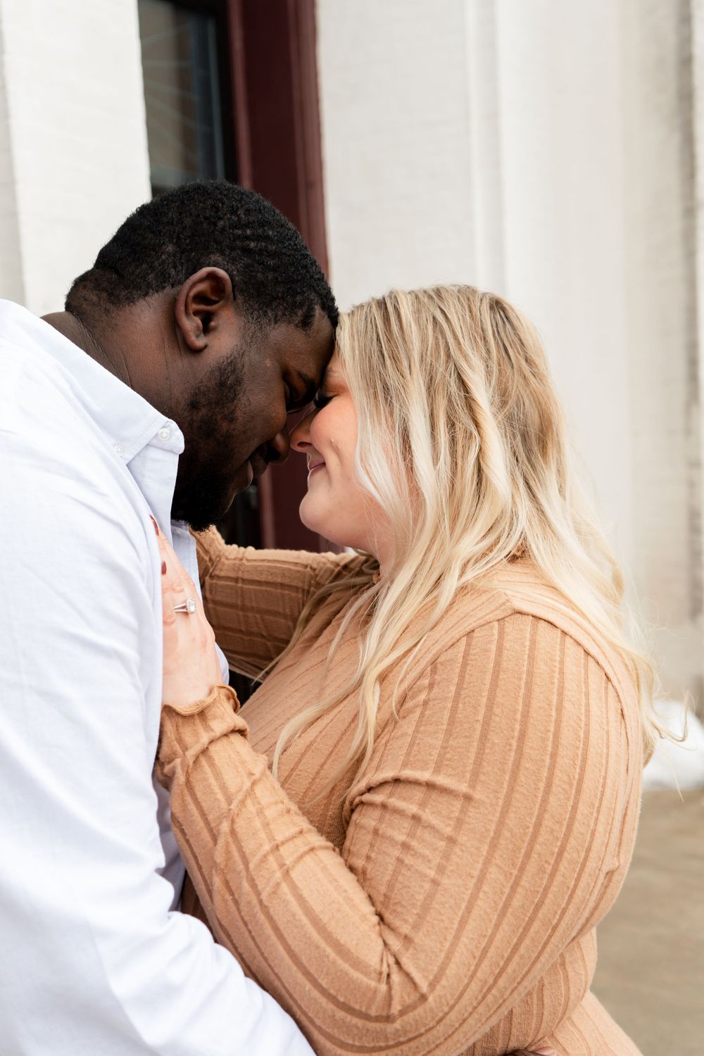 A loving couple embraces closely during their engagement photo session.