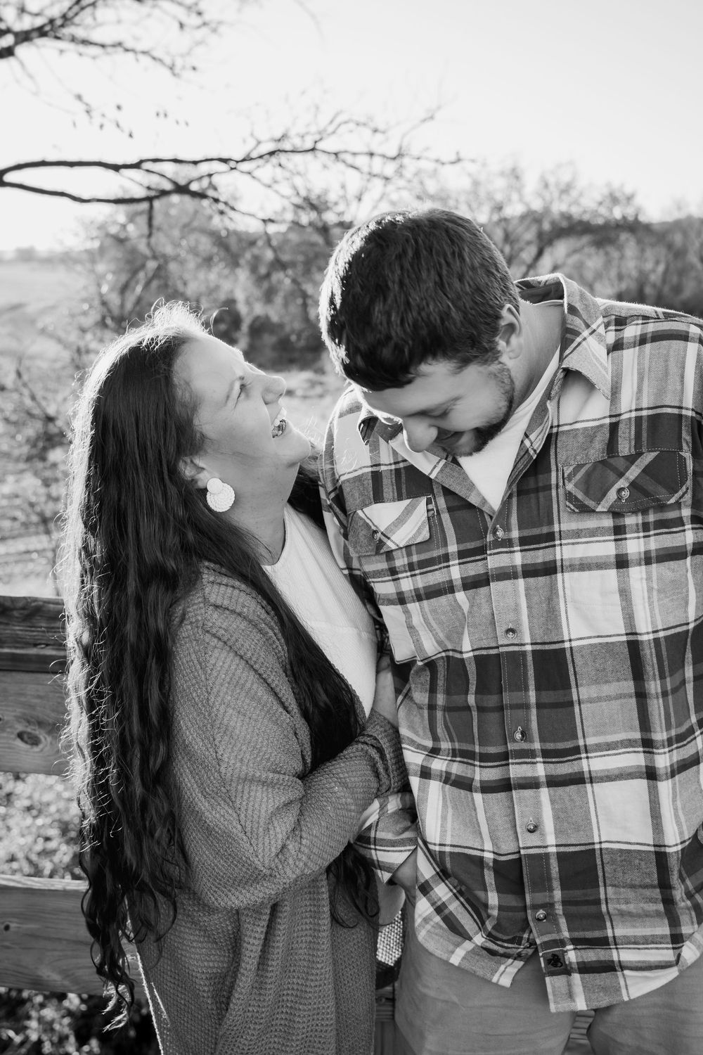 A romantic black and white photo series showing a couple sharing tender moments outdoors in casual attire.