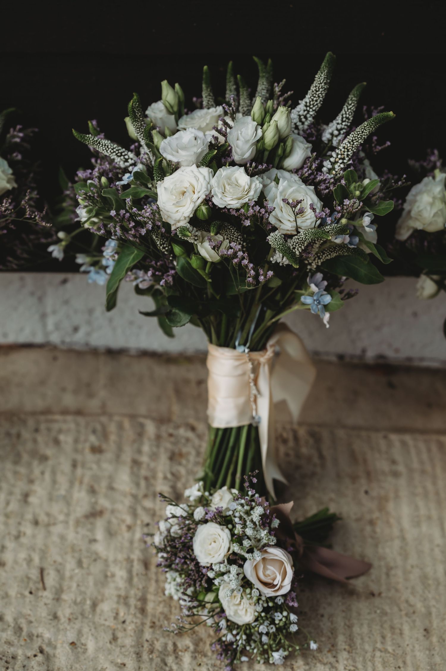 Beautiful rustic wedding bouquet with white roses and purple wildflowers wrapped in twine ribbon with matching boutonniere.