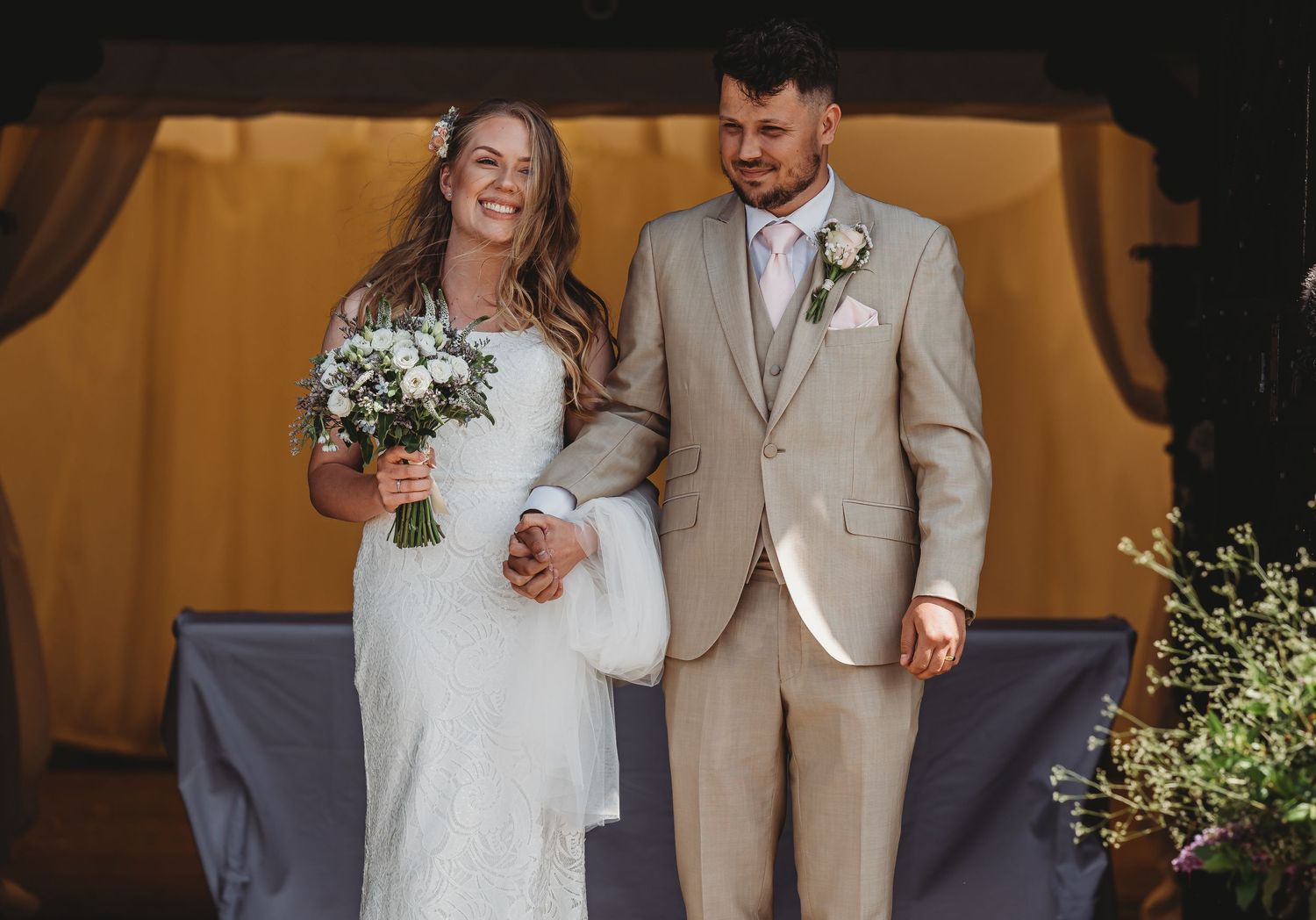 A joyful scene at a wedding ceremony with rustic decor and warm lighting.