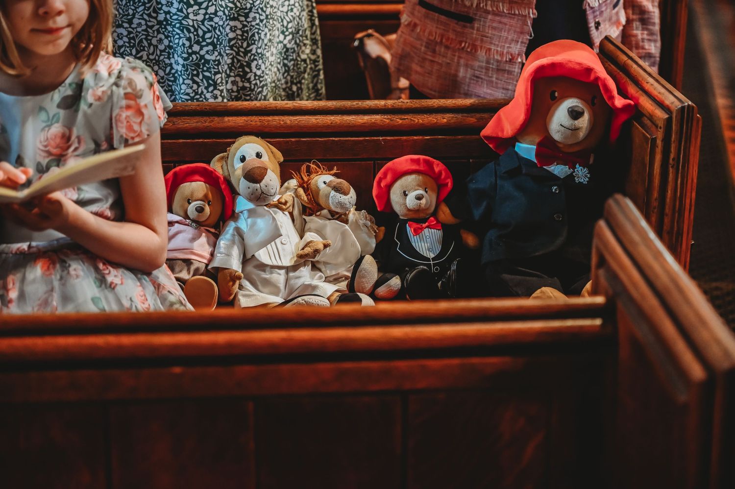 A collection of vintage-style stuffed bears and plush toys arranged in a wooden chest or shelf.