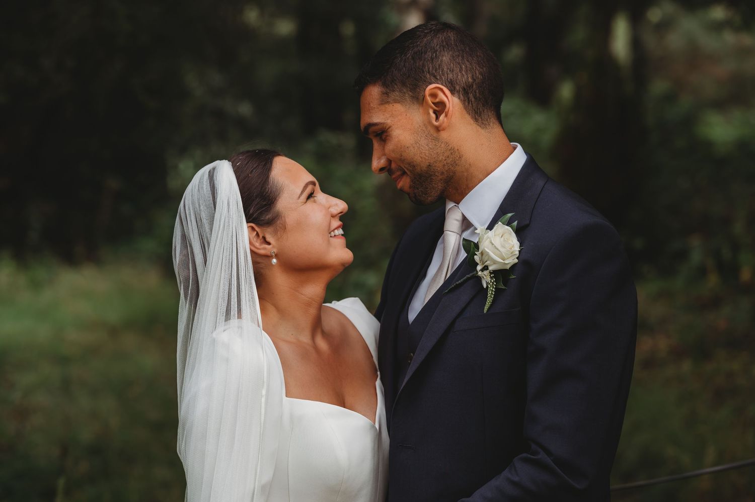 A tender moment captured between newlyweds in a natural outdoor setting.