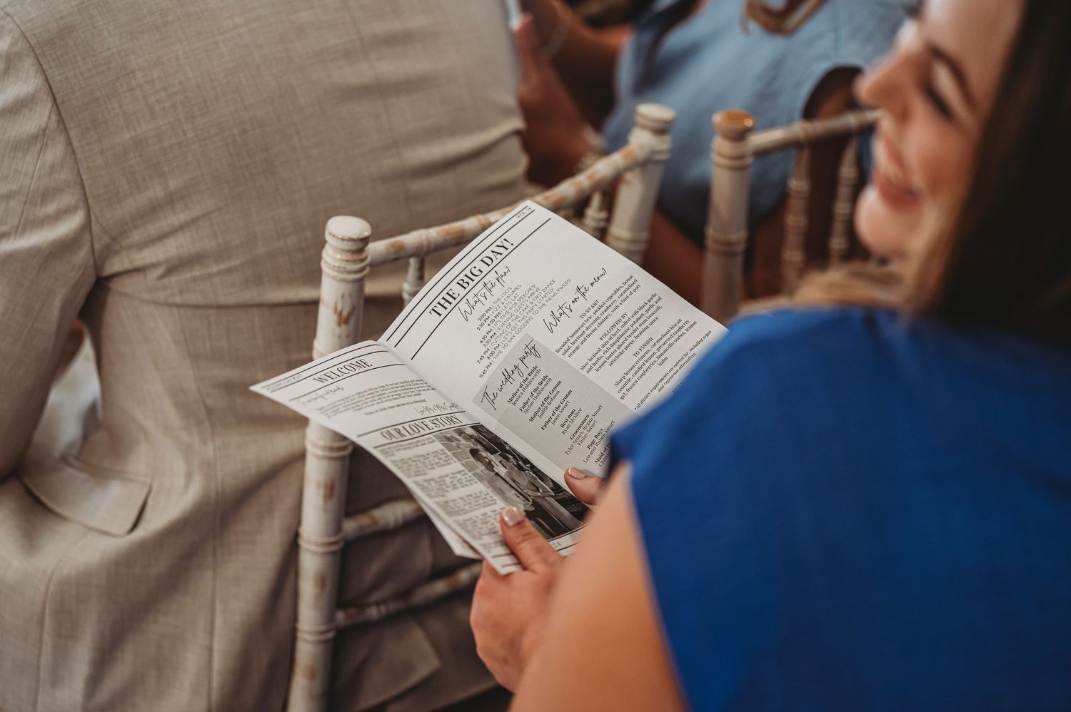 Guest reading wedding ceremony program during the celebration.