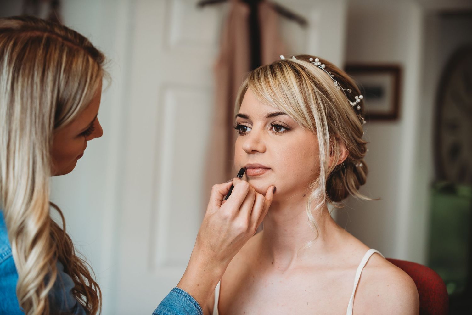 A makeup artist applies final touches before a special event with delicate precision and attention to detail.