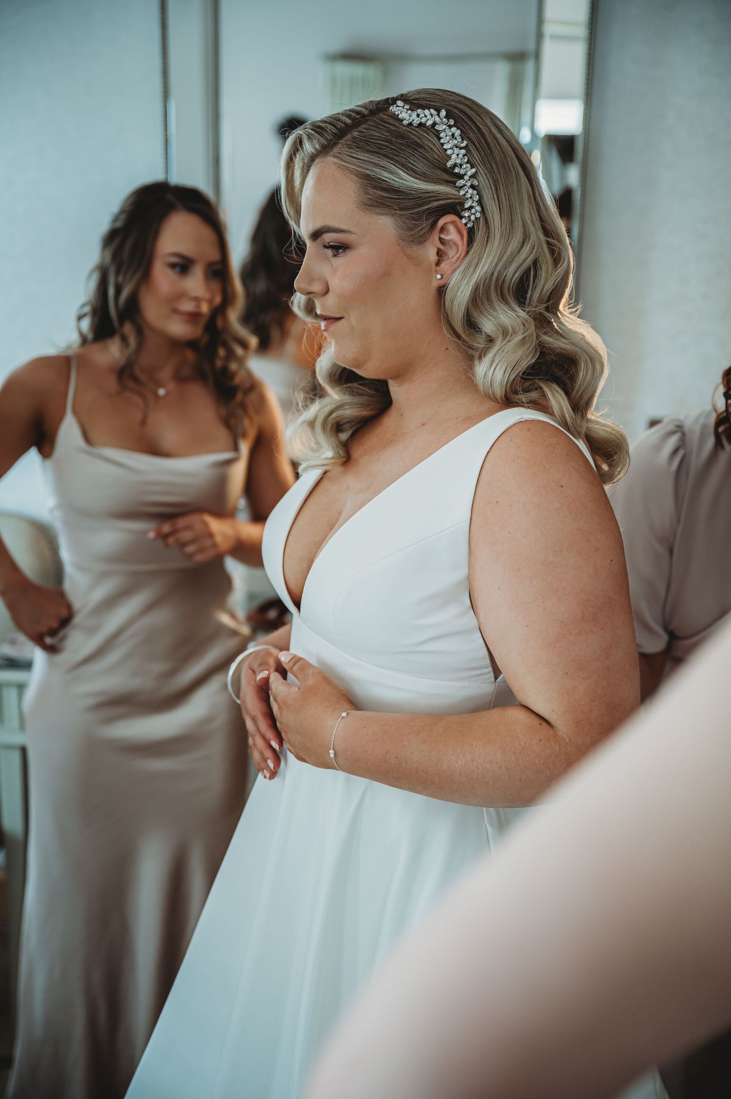 Elegant wedding preparation scene with flowing white dress and sparkly hair accessory against a soft interior backdrop.