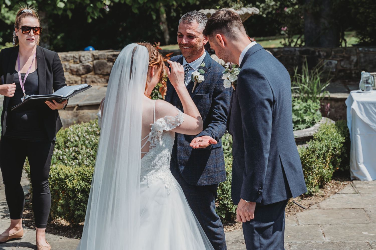 A tender moment during an outdoor garden wedding ceremony as the couple exchanges vows.