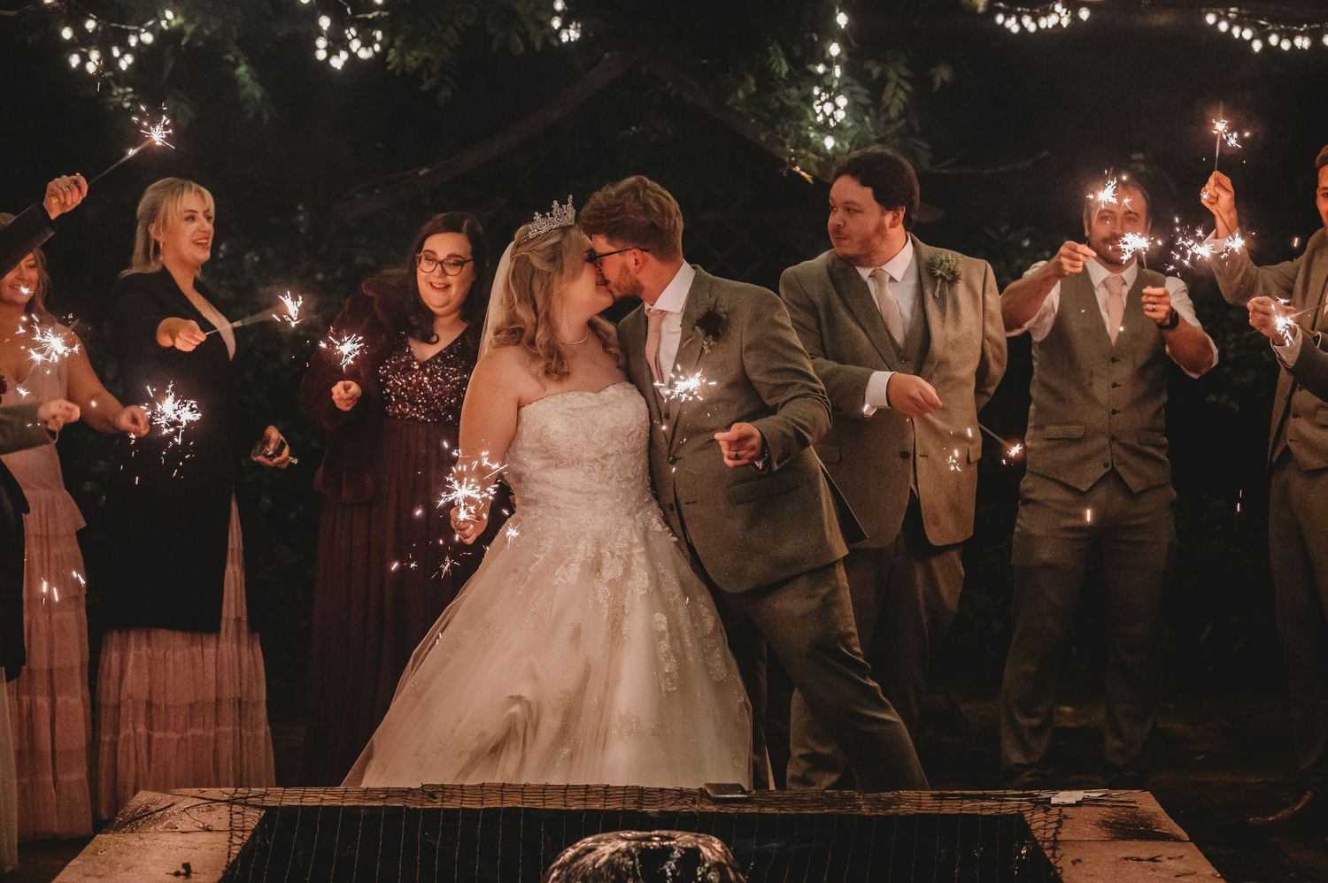 Wedding celebration at night with sparklers illuminating the outdoor festivities.