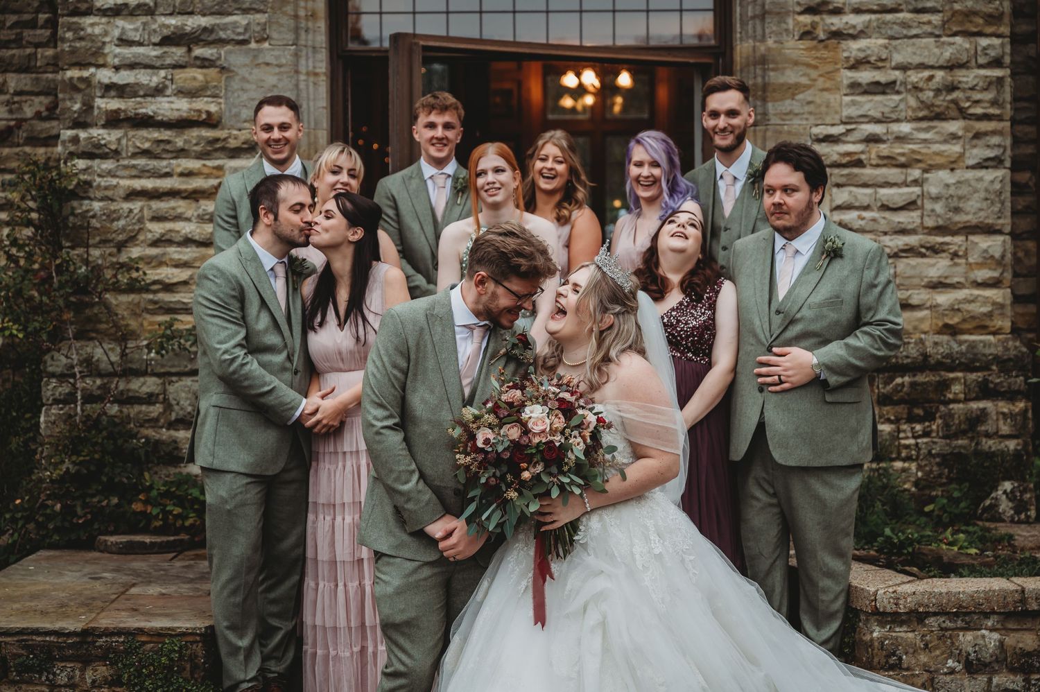 Wedding group portrait with attendants in mint green suits and pink dresses.
