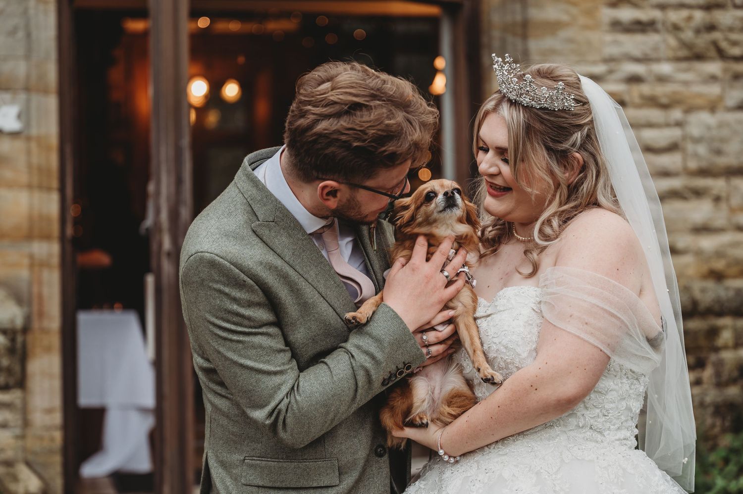 A couple sharing a tender moment with their pet at their wedding.