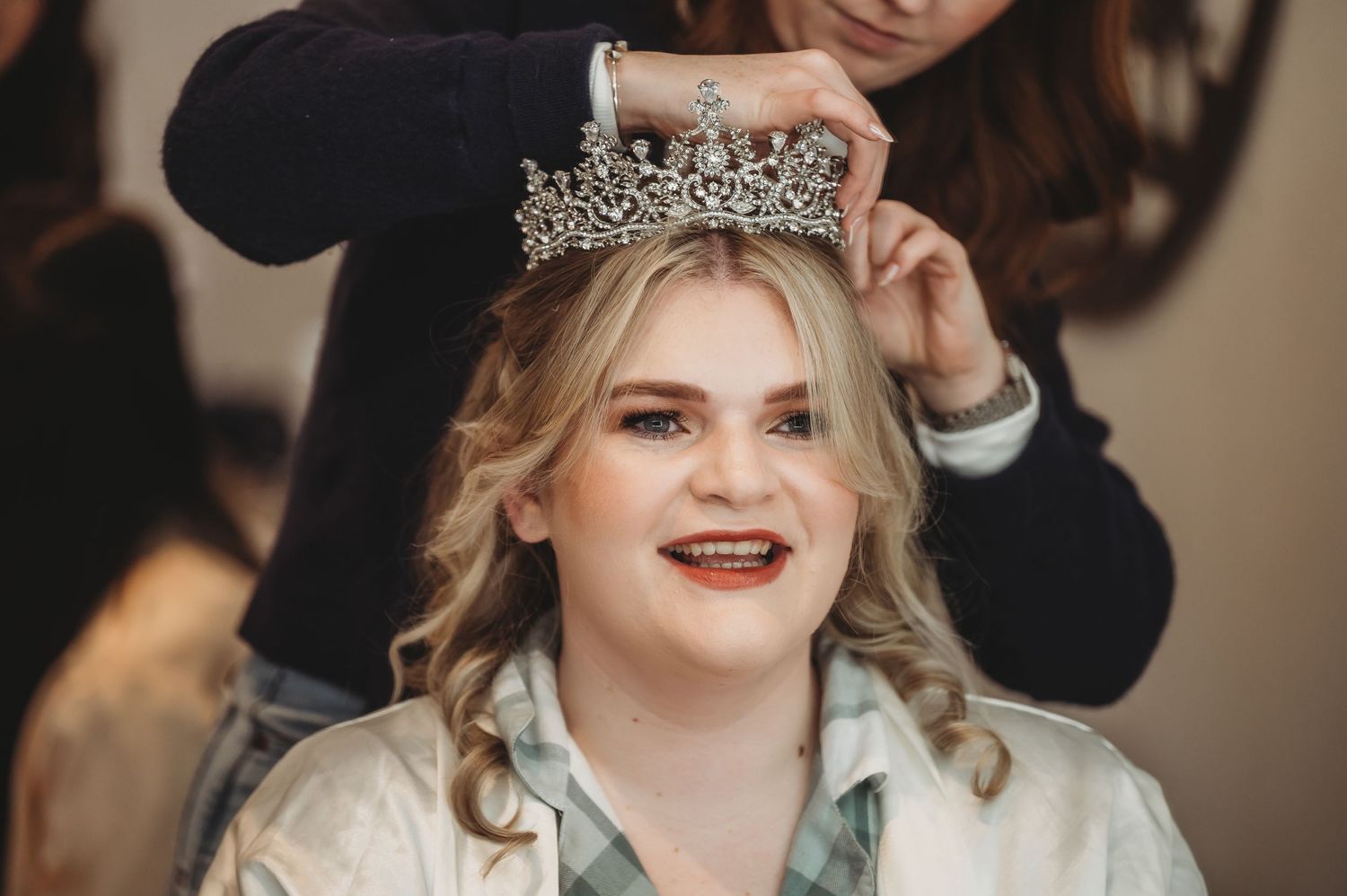 Wedding preparation moment with a silver tiara being placed.