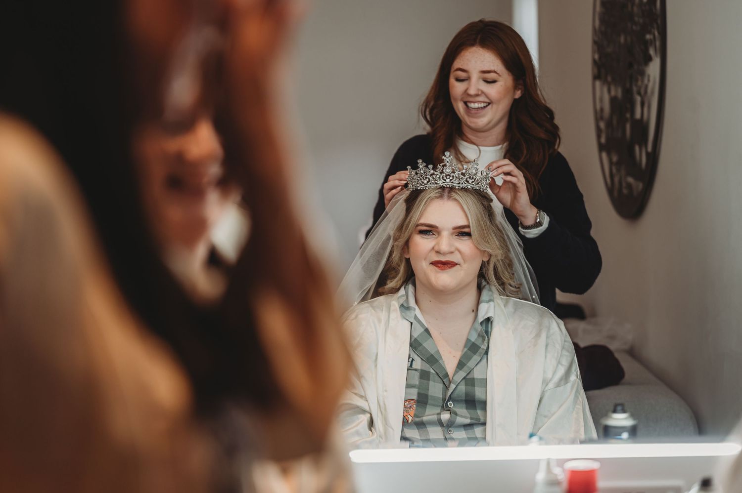 Wedding preparation scene showing final touches being done in a brightly lit room.