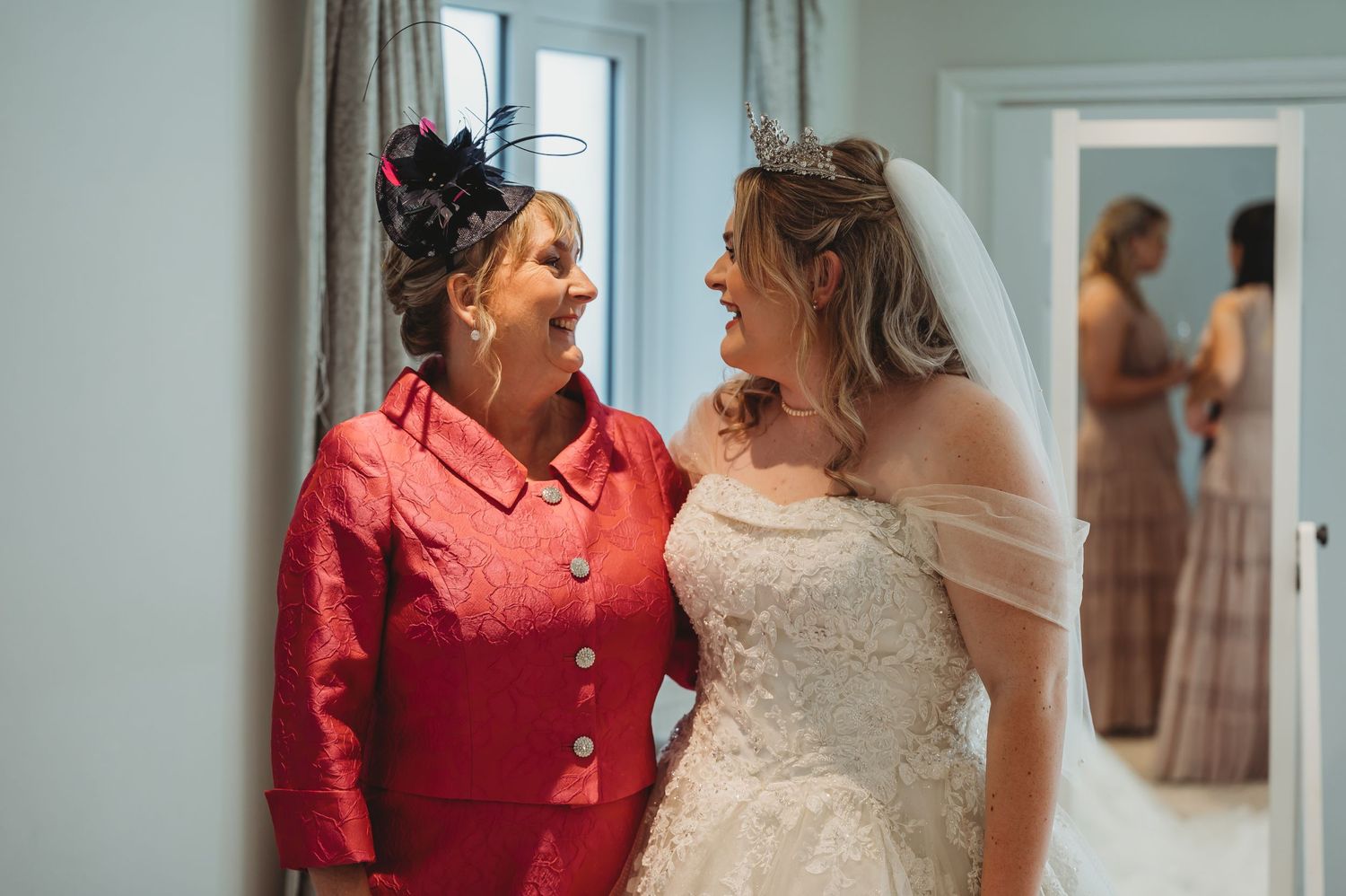 Emotional wedding day moment captured in bright interior hallway.