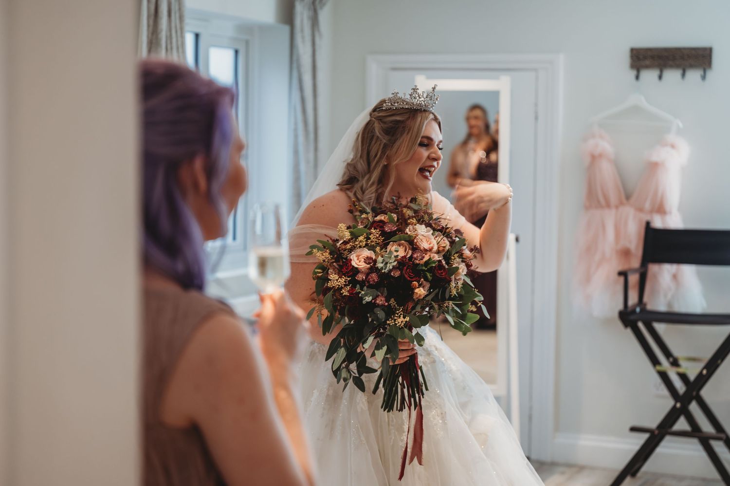 Bridal preparation moment with elegant floral bouquet and flowing white gown.