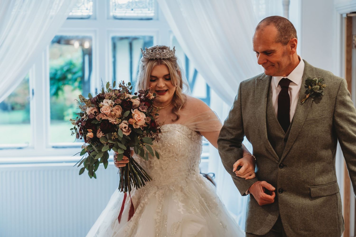 Bright sunlit wedding ceremony moment with stunning floral bouquet in hand.