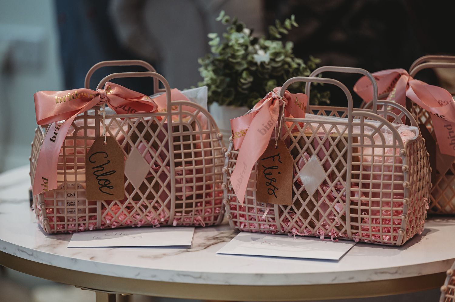 Pink retro-style gift baskets with ribbons arranged on a table.