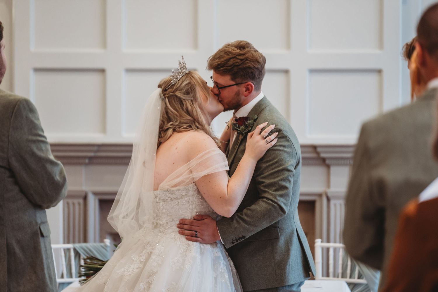 Tender moment shared during wedding ceremony in classic white venue.