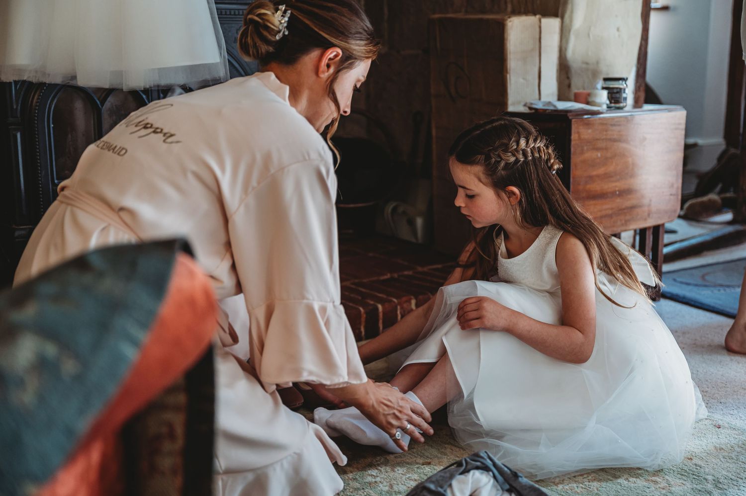 A touching pre-wedding moment showing preparations indoors with soft vintage lighting.
