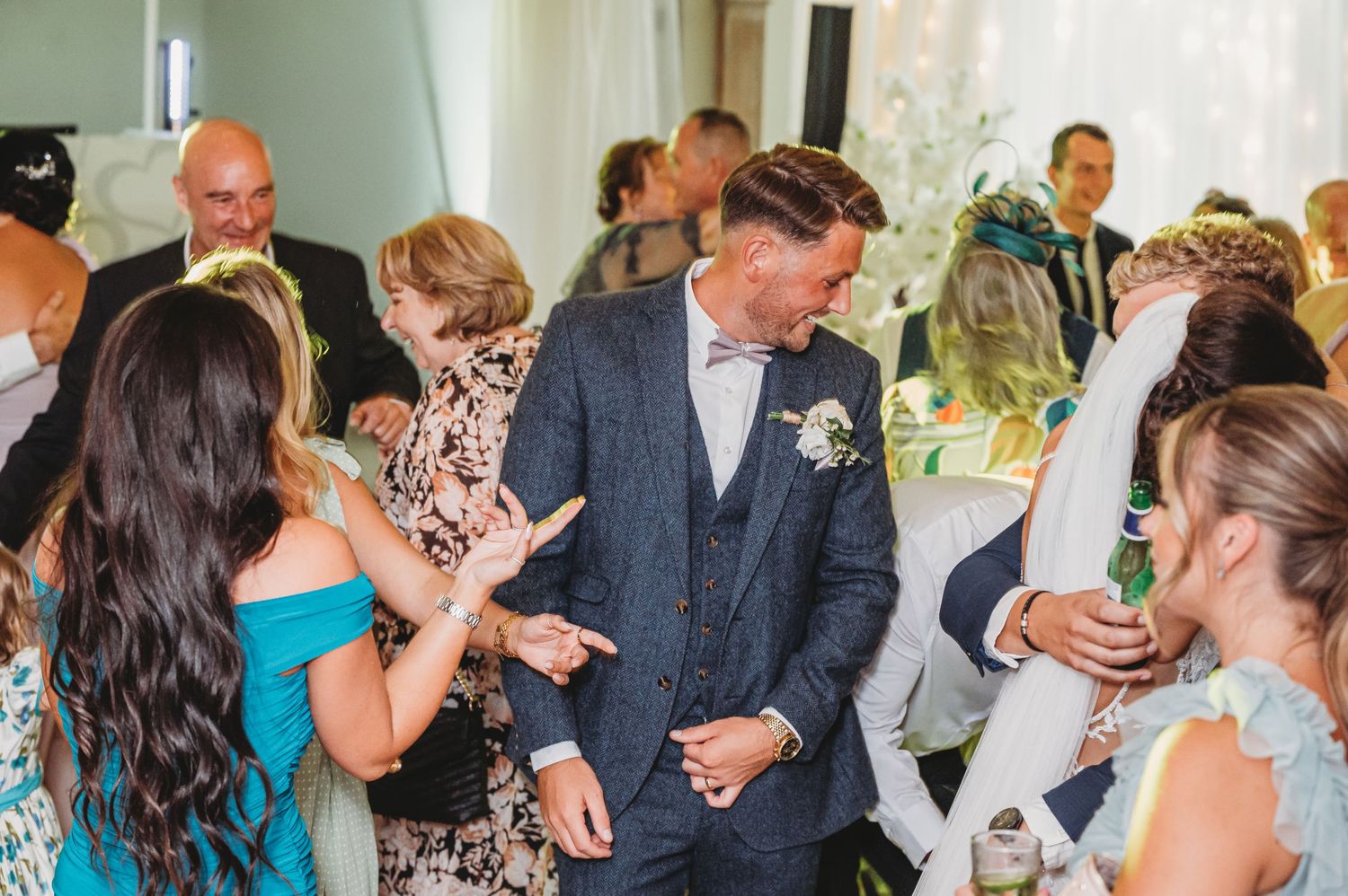 Wedding guests enjoying themselves on the dance floor at a reception celebration with dancing and festivities.