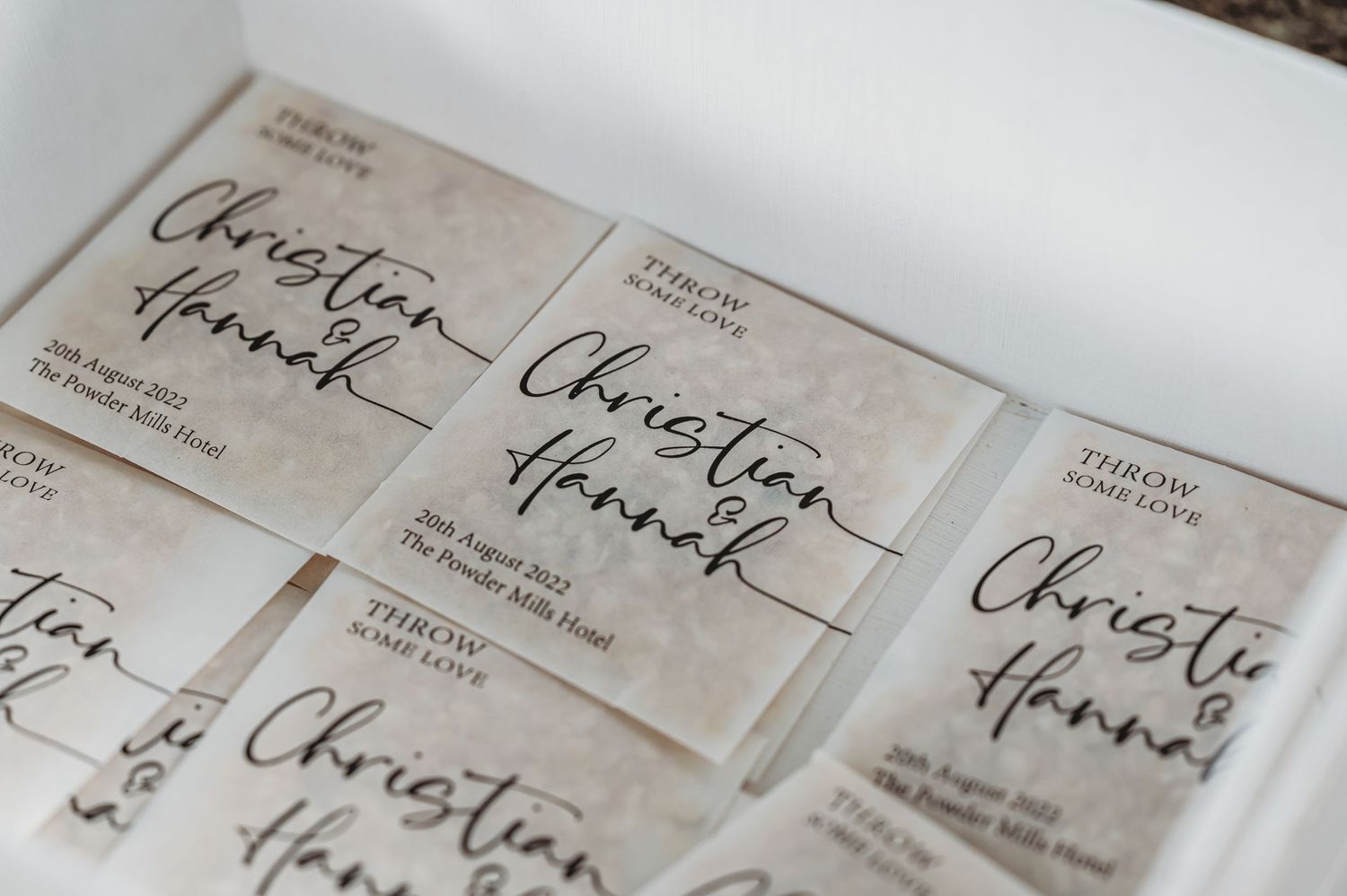 Handwritten-style text labels with elegant calligraphy writing on cream colored paper tags arranged together.