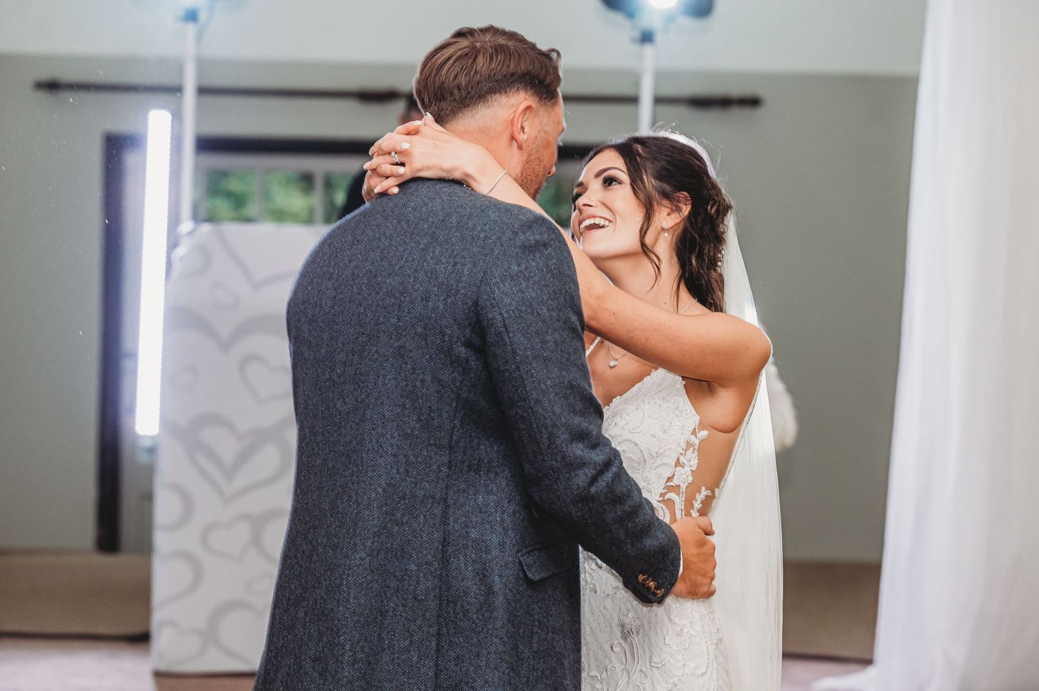 A bride and groom share an intimate dance together at their wedding reception in an elegantly decorated venue.