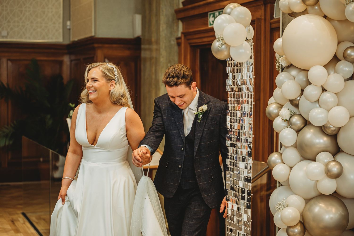 Wedding celebration with white balloon arch decorations in an elegant venue.